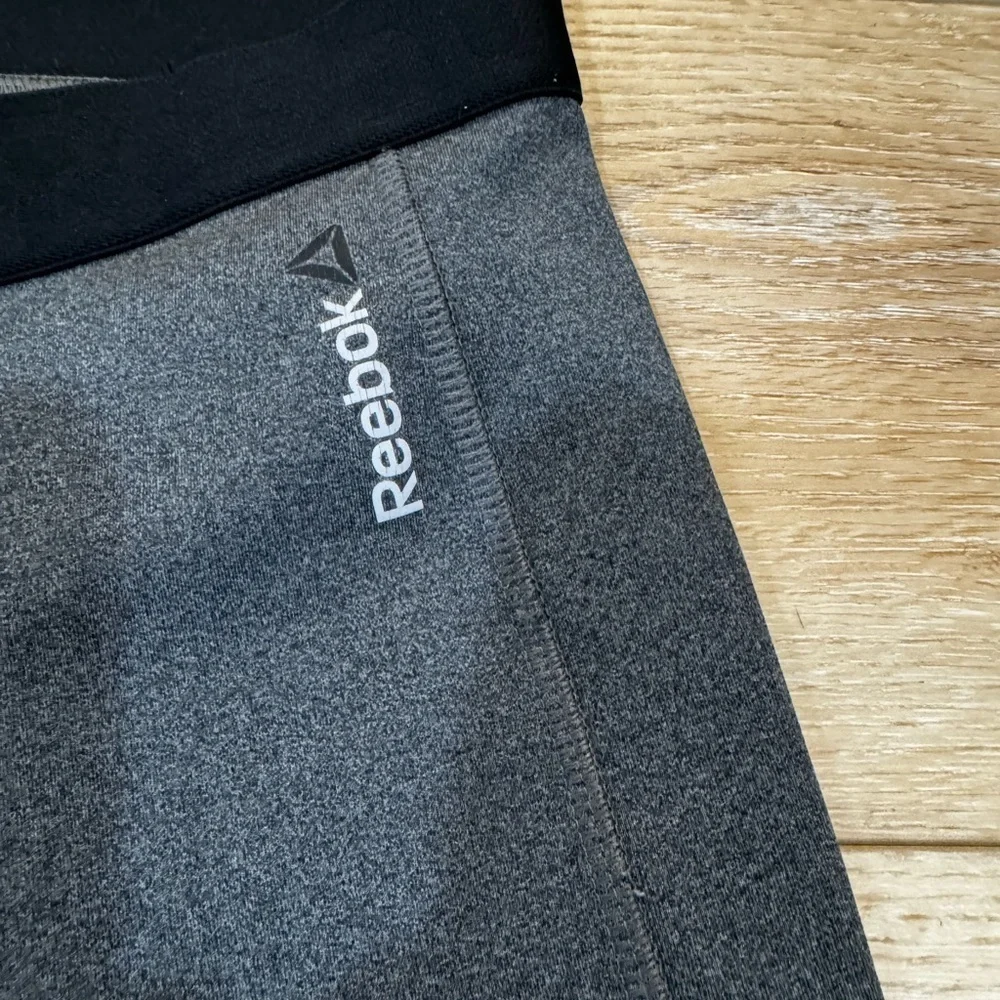 Reebok charcoal gray athletic leggings, mesh patterned detailing on side, S.